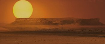 Movie still from “The Mummy” (1999), directed by Stephen Sommers – The sun is setting over a desert landscape; Extreme Wide shot, Low angle
