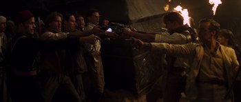 Movie still from “The Mummy” (1999), directed by Stephen Sommers – A group of people holding guns in a room; Medium shot, High angle