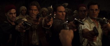Movie still from “The Mummy” (1999), directed by Stephen Sommers – A group of men holding guns in a dark room; Medium shot, High angle