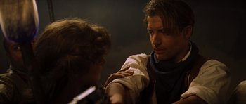 Movie still from “The Mummy” (1999), directed by Stephen Sommers – A man with long brown hair is holding a woman's arm; Close Up shot, Over the shoulder angle