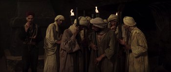 Movie still from “The Mummy” (1999), directed by Stephen Sommers – A group of men standing next to each other with torches; Wide shot, High angle
