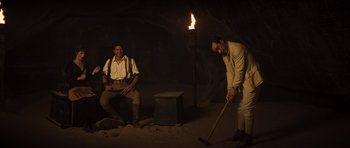 Movie still from “The Mummy” (1999), directed by Stephen Sommers – Two men are sitting in a cave with a fire; Wide shot, High angle