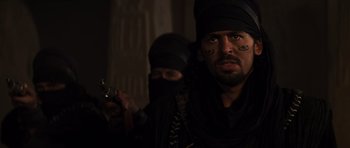 Movie still from “The Mummy” (1999), directed by Stephen Sommers – A man with a gun in his hand and another man in a black headscarf; Close Up shot, Over the shoulder angle