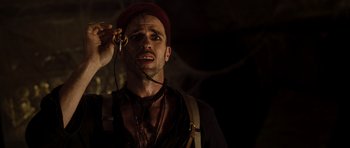 Movie still from “The Mummy” (1999), directed by Stephen Sommers – A man in a red hat holding a key; Close Up shot, High angle