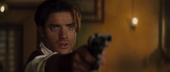 Movie still from “The Mummy” (1999), directed by Stephen Sommers – A person holding a gun; Close Up shot, Over the shoulder angle