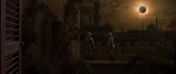 Movie still from “The Mummy” (1999), directed by Stephen Sommers – Two men in hats are standing in front of a building; Extreme Wide shot, High angle