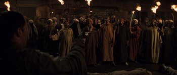Movie still from “The Mummy” (1999), directed by Stephen Sommers – A group of men in robes and headpieces holding torches; Wide shot, High angle