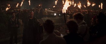 Movie still from “The Mummy” (1999), directed by Stephen Sommers – A group of people standing around with torches in the dark; Wide shot, Over the shoulder angle