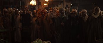 Movie still from “The Mummy” (1999), directed by Stephen Sommers – A group of people standing next to each other holding torches; Wide shot, High angle