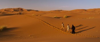 Movie still from “The Mummy” (1999), directed by Stephen Sommers – Two people are walking through the sand in the desert; Extreme Wide shot, High angle