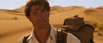 Movie still from “The Mummy” (1999), directed by Stephen Sommers – A person with a backpack in the desert; Close Up shot, Over the shoulder angle