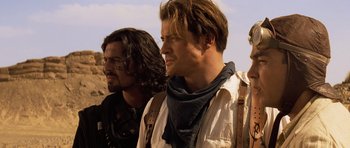 Movie still from “The Mummy” (1999), directed by Stephen Sommers – Two men standing next to each other on a dirt field; Close Up shot, Over the shoulder angle