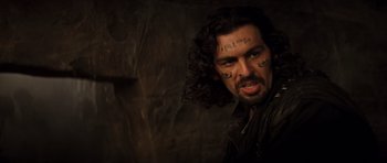 Movie still from “The Mummy” (1999), directed by Stephen Sommers – A man with long black hair and tattoos on his face; Close Up shot, Over the shoulder angle