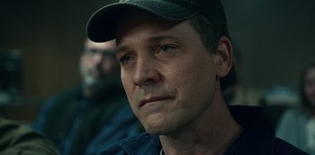 Movie still from “Dopesick” (2021), directed by Danny Strong – A person wearing a hat; Close Up shot, Over the shoulder angle