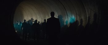 Movie still from “The Mummy” (2017), directed by Alex Kurtzman – A group of people standing inside of a tunnel at night; Wide shot, Low angle