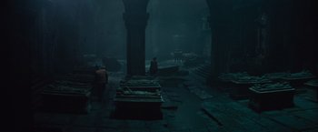 Movie still from “The Mummy” (2017), directed by Alex Kurtzman – A group of people standing in a dark room; Extreme Wide shot, High angle