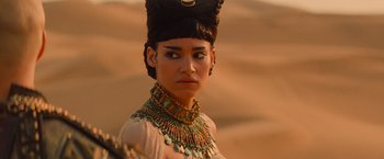 Movie still from “The Mummy” (2017), directed by Alex Kurtzman – A woman in a costume is standing in the desert; Close Up shot, Over the shoulder angle