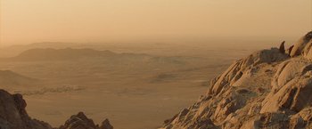 Movie still from “The Mummy” (2017), directed by Alex Kurtzman – A view of a desert landscape from a hill; Extreme Wide shot, High angle