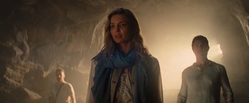 Movie still from “The Mummy” (2017), directed by Alex Kurtzman – A woman with a scarf standing in a dimly lit room; Medium shot, Over the shoulder angle