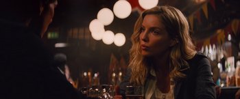 Movie still from “The Mummy” (2017), directed by Alex Kurtzman – A woman sitting at a table with a glass of wine; Close Up shot, Over the shoulder angle