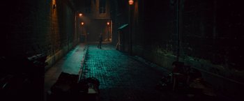 Movie still from “The Mummy” (2017), directed by Alex Kurtzman – A person standing on a street at night; Extreme Wide shot, High angle