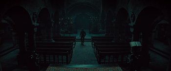 Movie still from “The Mummy” (2017), directed by Alex Kurtzman – A person walking in a dark room with many benches; Extreme Wide shot, High angle