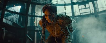 Movie still from “The Mummy” (2017), directed by Alex Kurtzman – A woman in chains is standing in a room; Medium shot, Low angle