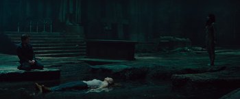 Movie still from “The Mummy” (2017), directed by Alex Kurtzman – A woman laying on the ground in the dark; Wide shot, High angle