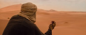 Movie still from “The Mummy” (2017), directed by Alex Kurtzman – A man in a turban holding something in his hand; Wide shot, High angle