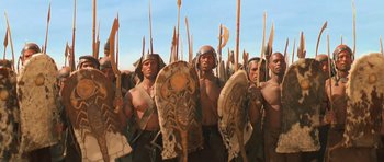 Movie still from “The Mummy Returns” (2001), directed by Stephen Sommers – A group of men standing next to each other holding spears; Medium shot, Low angle