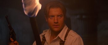 Movie still from “The Mummy Returns” (2001), directed by Stephen Sommers – A person holding a stick in a room; Close Up shot, Over the shoulder angle