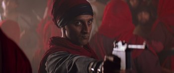 Movie still from “The Mummy Returns” (2001), directed by Stephen Sommers – A man in a red turban is holding a camera; Close Up shot, Low angle
