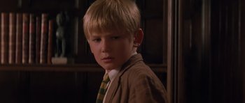 Movie still from “The Mummy Returns” (2001), directed by Stephen Sommers – A young boy wearing a suit and a tie; Close Up shot, Low angle