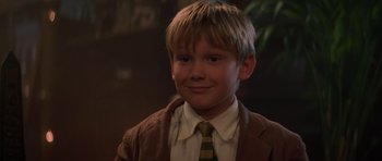 Movie still from “The Mummy Returns” (2001), directed by Stephen Sommers – A young boy wearing a suit and a tie; Close Up shot, Low angle