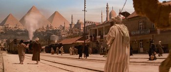 Movie still from “The Mummy Returns” (2001), directed by Stephen Sommers – A group of people standing on the side of a road; Extreme Wide shot, Low angle
