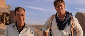 Movie still from “The Mummy Returns” (2001), directed by Stephen Sommers – Two men standing next to each other on a dirt field; Medium shot, Low angle