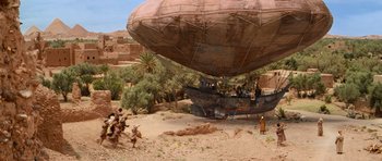 Movie still from “The Mummy Returns” (2001), directed by Stephen Sommers – An airship is being carried by a group of people; Extreme Wide shot, High angle