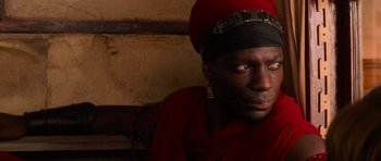 Movie still from “The Mummy Returns” (2001), directed by Stephen Sommers – A woman in a red dress and a black hat; Close Up shot, Over the shoulder angle