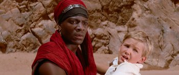 Movie still from “The Mummy Returns” (2001), directed by Stephen Sommers – A man with a red scarf on his head and a man with a white shirt on his chest; Close Up shot, Over the shoulder angle
