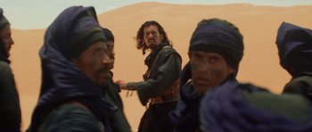 Movie still from “The Mummy Returns” (2001), directed by Stephen Sommers – A group of men standing next to each other in the desert; Medium shot, Over the shoulder angle