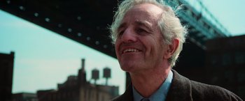 Movie still from “The New York Ripper” (1982), directed by Lucio Fulci – An older man with white hair smiling for the camera; Close Up shot, Low angle