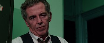 Movie still from “The New York Ripper” (1982), directed by Lucio Fulci – An older man wearing a vest and a tie; Close Up shot, Low angle