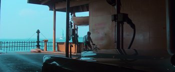 Movie still from “The New York Ripper” (1982), directed by Lucio Fulci – A man riding a bike in front of the statue of liberty; Extreme Wide shot, Low angle