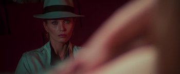 Movie still from “The New York Ripper” (1982), directed by Lucio Fulci – A woman wearing a hat looking into the camera; Close Up shot, Over the shoulder angle