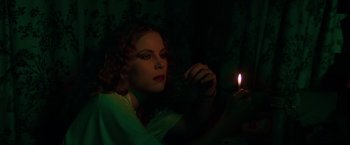 Movie still from “The New York Ripper” (1982), directed by Lucio Fulci – A woman holding a lit candle in a dark room; Close Up shot, High angle