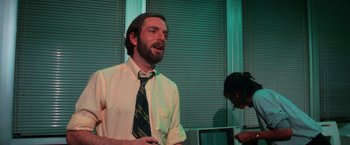 Movie still from “The New York Ripper” (1982), directed by Lucio Fulci – A man with a beard wearing a neck tie; Medium shot, Low angle