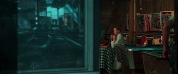Movie still from “The New York Ripper” (1982), directed by Lucio Fulci – A man sitting at a table in front of an open window; Wide shot, Over the shoulder angle