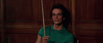Movie still from “The New York Ripper” (1982), directed by Lucio Fulci – A man in a green shirt holding a wooden stick; Close Up shot, Low angle