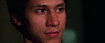 Movie still from “The New York Ripper” (1982), directed by Lucio Fulci – A man's face with a dark background; Close Up shot, Low angle