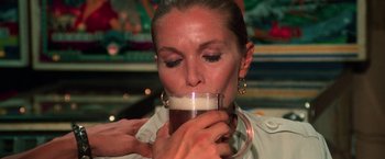 Movie still from “The New York Ripper” (1982), directed by Lucio Fulci – A person holding a cup of coffee; Close Up shot, Over the shoulder angle